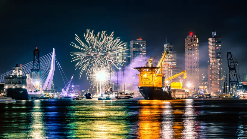 Vuurwerk boven de Maas met schepen en de skyline