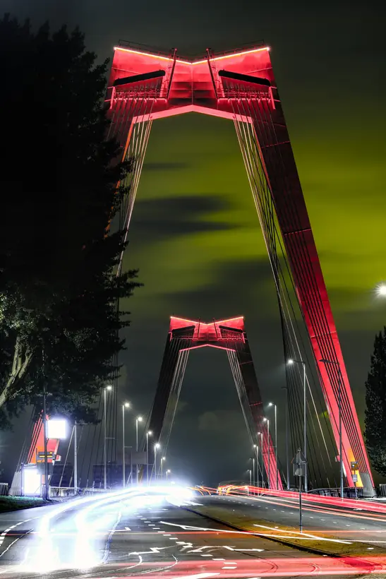 De rode Willemsbrug bij nacht met lichtsporen